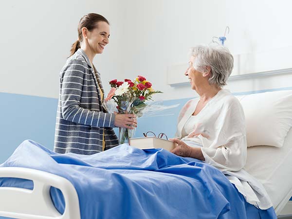 woman-visiting-a-senior-patient-and-giving-her-flo-2022-10-21-20-45-29-utc